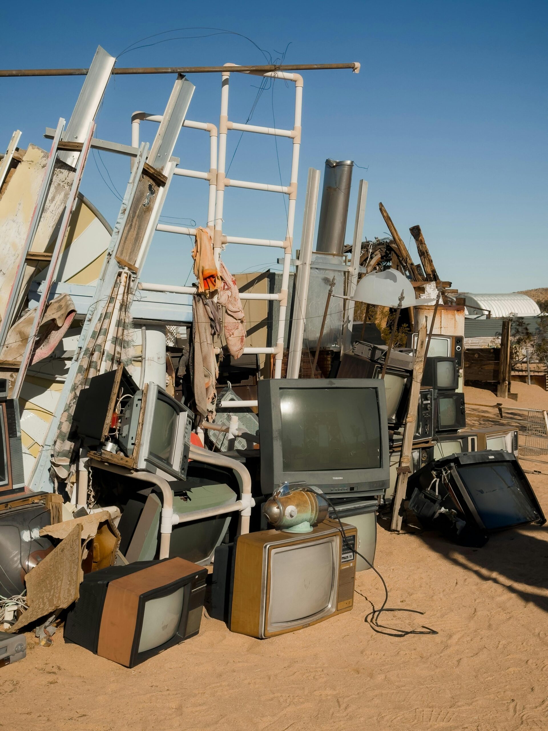 Abandoned TVs stacked in the Joshua Tree desert at a makeshift junkyard.